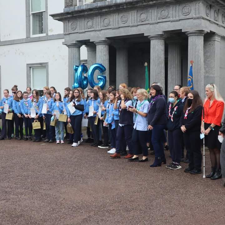Irish Girl Guides Ambassador Sinead Kane posing with a group of girl guides holding up certificates