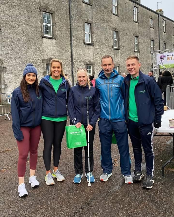 Marathon Running Coach John O'Regan and Ultra Runner Sinead Kane posing for a photo with members of Revive Active